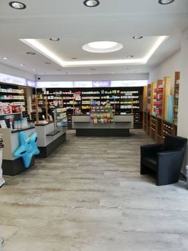 Apotheken Umbau – Breiter Verkaufsraum mit Sitzbereich und Produktregalen